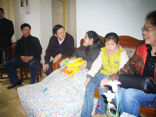 图为市残联理事会负责人侯定旺、沈楠和向科军与陈彩霞亲切话元宵