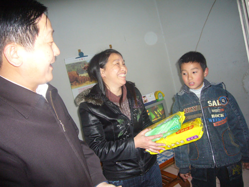 图为捧着“娘家人”送来的元宵，肢残人陈灿霞和儿子开心地笑了